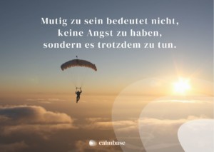 Ein Fallschirmspringer fliegt in den Sonnenuntergang. Auf dem Bild steht ein Zitat: Mutig zu sein bedeutet nicht, keine Angst zu haben, sondern es trotzdem zu tun.