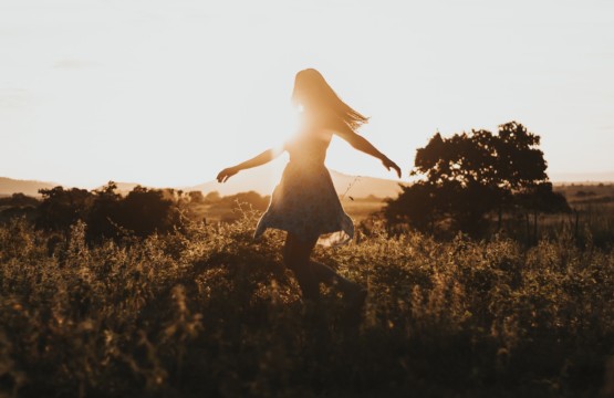 Eine Frau tanzt im Sonnenuntergang