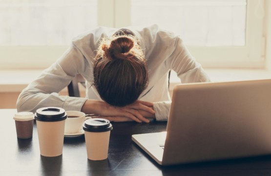 Antriebslosigkeit Frau mit Kopf auf dem Schreibtisch